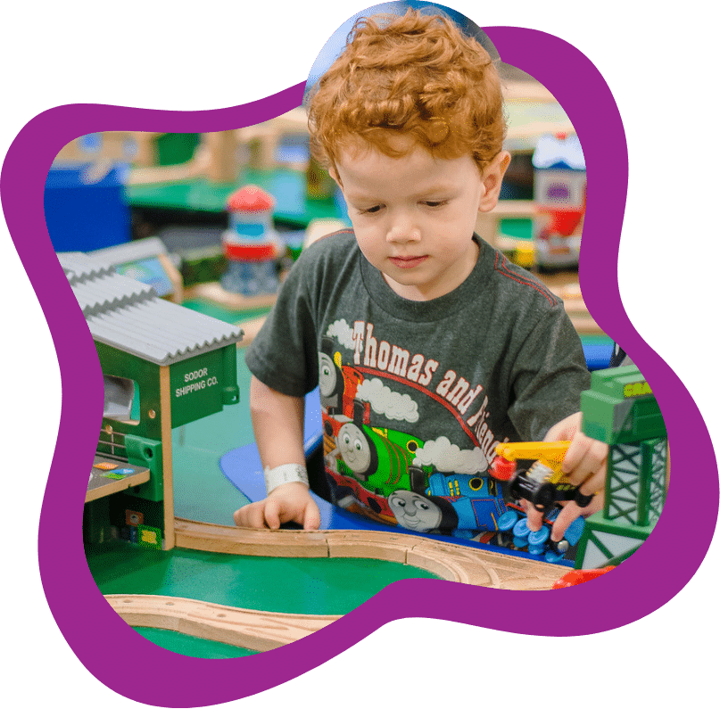 Boy playing with train set