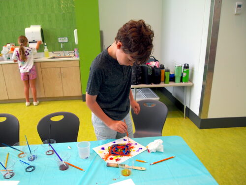 Young boy paints a picture at summer camp at the Mississippi Children's Museum - Meridian