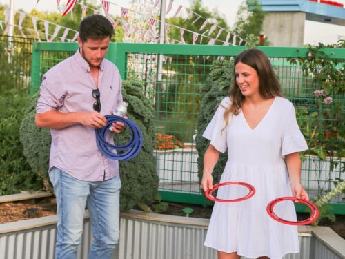 Man and woman playing ring toss in a garden